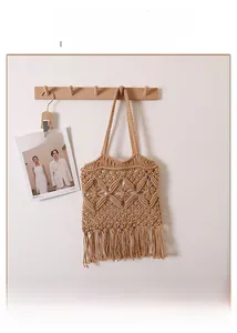 Close-up of bohemian hollow cotton rope woven bag with long tassel fringe detail