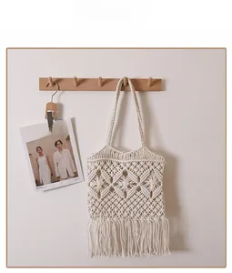 Detailed view of bohemian cotton woven shoulder bag with diamond hollow pattern and tassels