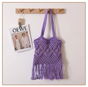 Detail of purple cotton crochet shoulder bag with hollow diamond pattern and long tassels