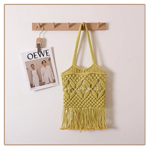 Detailed view of yellow macrame woven tote bag with long tassels and geometric patterns