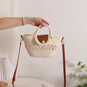 Handwoven crossbody bag with cotton cord, pearl button, and brown leather flap detail