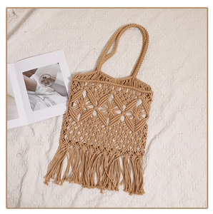 Detail of hollow woven cotton tote bag with long tassels and bohemian knit patterns