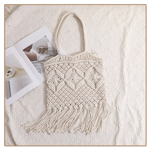 Detail of bohemian cream cotton rope woven tote bag with hollow geometric patterns and tassels