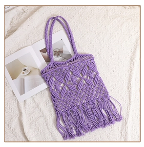 Detail of purple woven cotton shoulder bag with hollow mesh design and stylish long tassels