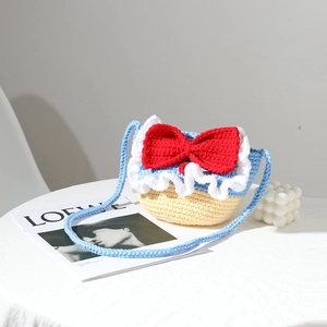 Handmade crochet crossbody bag with red bow and blue-yellow color block design