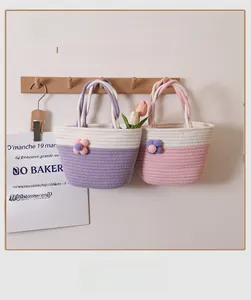 Close-up of hand-woven cotton rope bag with colorful plush flower and textured knit detail