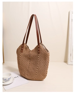Detail of V-shaped crochet texture on tan woven bag with brown leather shoulder strap