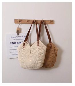 Close-up of woven cotton tote bag showing V-shaped texture and brown leather handle