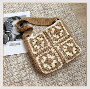 Close-up of handmade granny square crochet shoulder bag in earth tones on woven rug