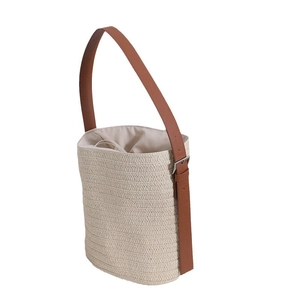 Handcrafted straw bucket bag in oatmeal beige with brown leather strap and drawstring liner