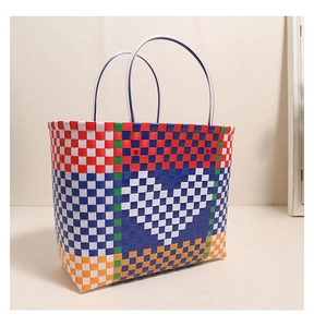 Close-up of multicolor woven plastic tote with heart pattern and clear handles