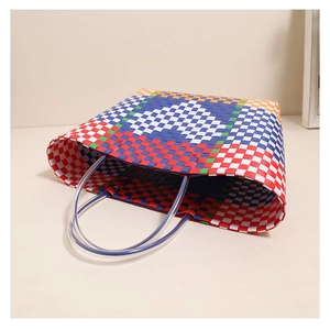 Close-up of heart pattern on multi-color woven plastic tote bag with clear handles
