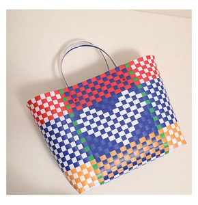 Detailed texture of colorful checkered plastic woven tote bag with durable handles