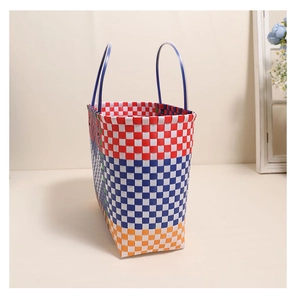 Detail showing colorful plaid plastic woven baskets with handles in a minimalist setting