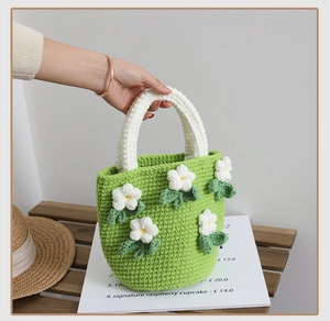 Close-up of handmade green knit tote bag with white floral 3D crochet patterns