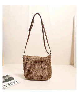 Detailed macro view of the hand-woven straw bag with premium brown leather patch and zipper