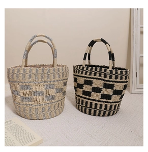 Dettaglio di borse a secchiello in paglia intrecciata nei colori beige-argento e nero