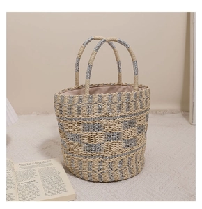 Dettaglio borsa a secchiello in paglia intrecciata a scacchi beige e argento con manici