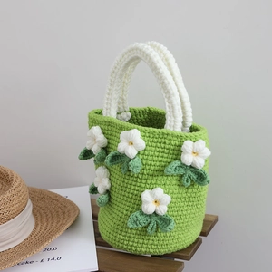 Handmade green camellia crochet bucket bag with 3D floral accents and woven white handle