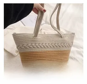 Detail of two-tone cotton weave shoulder bag featuring metal zipper and braided texture