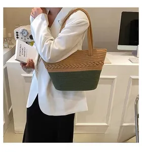 Detailed view of bicolor woven cotton tote bag worn with white blazer and black skirt