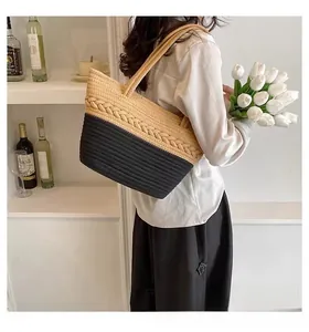Detail view of large woven cotton shoulder bag with two-tone straw texture and beige strap