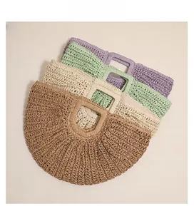 Detail showing the woven texture and four color options for the crescent straw bag
