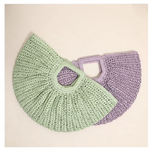 Close-up of mint green and lavender crescent straw bags with woven pleated textures