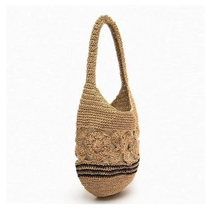 Detailed macro of handmade floral crochet weave on a straw shoulder bag with black stripes