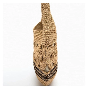 Close-up of hollow flower weave pattern and brown stripes on straw beach tote bag