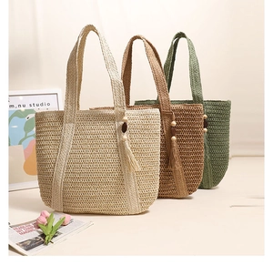 Detailed close-up of woven tote bags in beige, coffee, and green with tassel ornaments