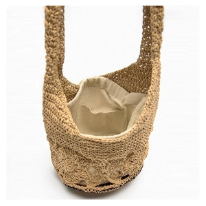 Internal view of the beige woven straw bag showing the cotton lining and inner pocket