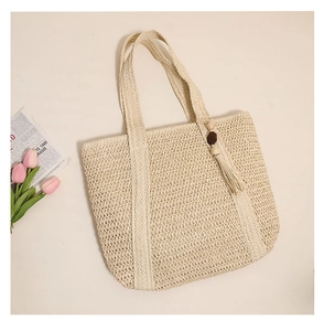 Detail of hand-woven straw tote bag with brown wood beads and fringe tassel accessory