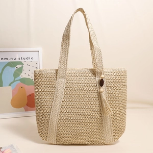 Beige handwoven straw tote bag with tassel charm for beach vacation and summer style