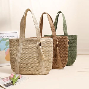 Large woven straw tote bags in beige, green and tan with decorative wooden bead tassels