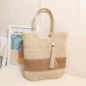 Zweifarbige gewebte Strohtasche in Beige und Braun mit Quastenanhänger für den Strand