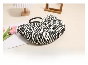 Detail of hand-woven semi-circle straw bag showing black and white wavy texture