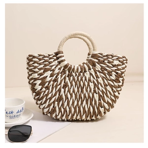 Detail of a semi-circular woven straw bag with two-tone brown and white wave texture