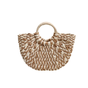 Minimalist half-moon woven straw handbag with circular handles for beach vacations