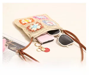 Detail view of woven flower crossbody bag interior with zip closure and items inside