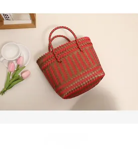 Vue de dessus d'un sac de plage tressé rouge et marron avec tulipes et café sur table
