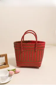 Détail du motif tressé rouge et marron d'un sac de plage carré avec des poignées solides