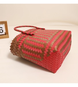Détail du sac de plage tressé rouge et marron avec motif géométrique et anse solide
