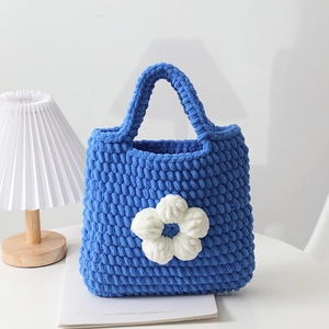Borsa a mano blu fatta a mano all'uncinetto con grande fiore bianco decorativo