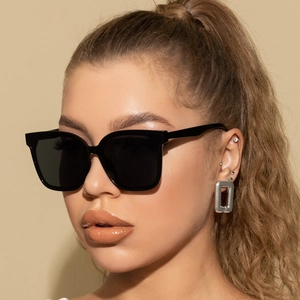 Nahaufnahme der klassischen schwarzen Square-Sonnenbrille mit glänzendem Finish am Damenmodell