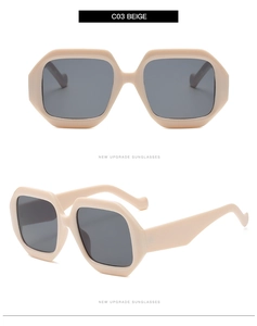 Dettagli di occhiali da sole geometrici beige con montatura spessa e lenti grigio scuro