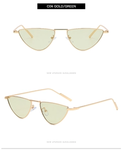Detail view of small triangle cat-eye sunglasses with gold metal frame and green lenses