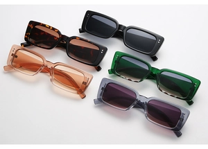 Macro view of five retro rectangular sunglasses in various colors on a white background