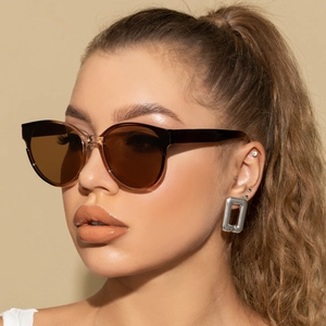 Close-up of stylish oversized round sunglasses with brown lenses on a female model