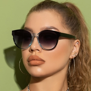 Close-up of oversized cat-eye sunglasses with grey gradient lenses and two-tone frame